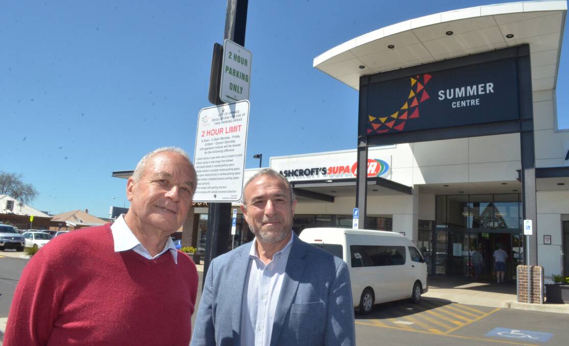 Orange City councillor Russell Turner and Summer Centre manager Bill Kanellopoulos, with a new sign advising of a two parking limit. Photo: DECLAN RURENGA 1014drpark2