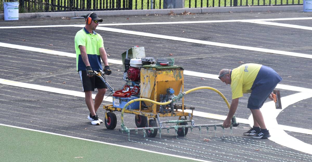 IMPROVEMENTS: Workers are putting the finishing touches on the new turf at the Orange Hockey Complex. Photo: JUDE KEOGH