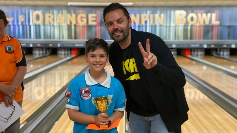 A PROUD FATHER: Hugo Belmonte accepts his trophy from father Jason after Orange Tenpin's first tournament back since COVID. 