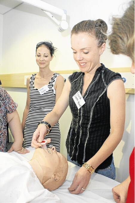 TRAINING: Fiona Scott-Young practises her airway management techniques under the watchful eye of trainers and other clinicians from the central west. Photo: MARK LOGAN 1115trauma