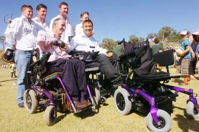 HANDOVER: Peter Worsley (left) is presented with a new wheelchair by Hearts in Union founder Rocky Mileto at the half-time interval of the  Harper Bernays Rugby Challenge match at Millamolong on Satur
