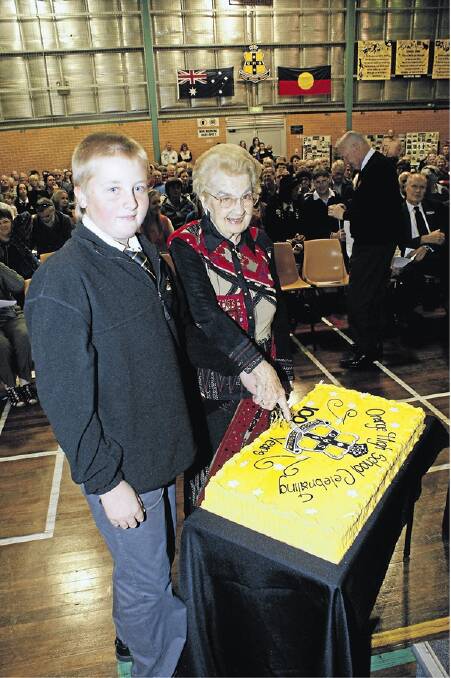 MILESTONE: Lady Dorothy Cutler, whose husband Sir Charles Cutler attended Orange High School, cuts the centenary cake with student Lachlan Madden, whose grandfather Max Madden was the school’s principal from 1986-1991.  Photo: MARK LOGAN  0428mlohs13