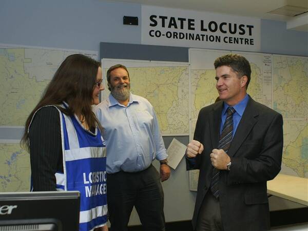 ROUND ONE: Primary industries minister Steve Whan squares up for a fight against the worst locust plague in 30 years while meeting Plague Locust State Coordination Centre staff Shanene Crimeen and Tim Seears. Photo: MARK LOGAN                                         0809mllocusts5
