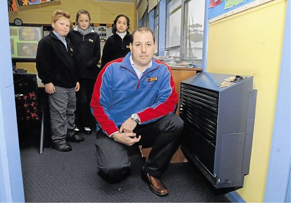 HEATING UP: Orange East Public School assistant principal Glen Bourke and students Oscar Ward, Casey Ryan and Leizeyah Knowles were pleased in 2010 knowing their unflued heaters would be replaced.