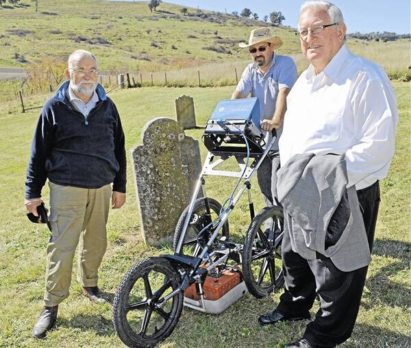 LOOKING FOR CLUES: Orange and District Historical Society member Phil Stevenson, Simon Williams from GBG Australia and Orange mayor John Davis search for unmarked graves at the Chinamans Bend cemetery last week.
