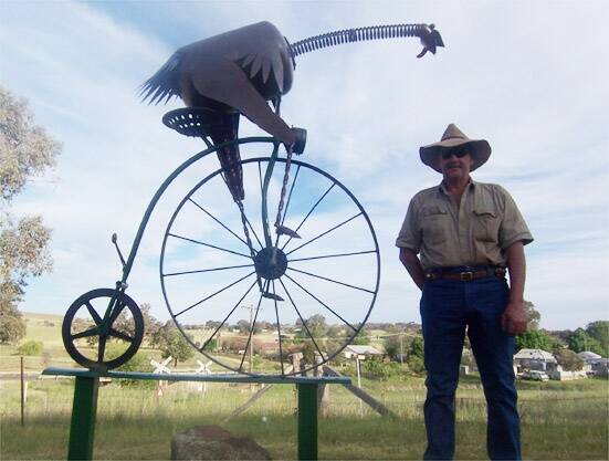 PADDOCK ART: Les Roberts with the emu on a penny-farthing he built for the Animals on Bikes project.