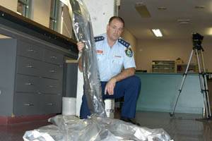 ASSAULT WEAPON: Chifley local area command duty officer Chris Davey with some of the guns seized during a raid on a Bathurst warehouse on Tuesday. He is pictured holding an SKS assault rifle that was part of the cache. Photo: BRIAN WOOD