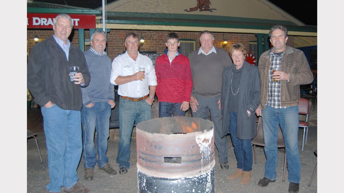 Neville Stag players, Greg and Philip Bird, Craig Johns and Chris Bird (far right) gather around a fire bucket with Blake Peak, Trevor Henry and Mary O’Brien.  Photo: Wayne Cock.