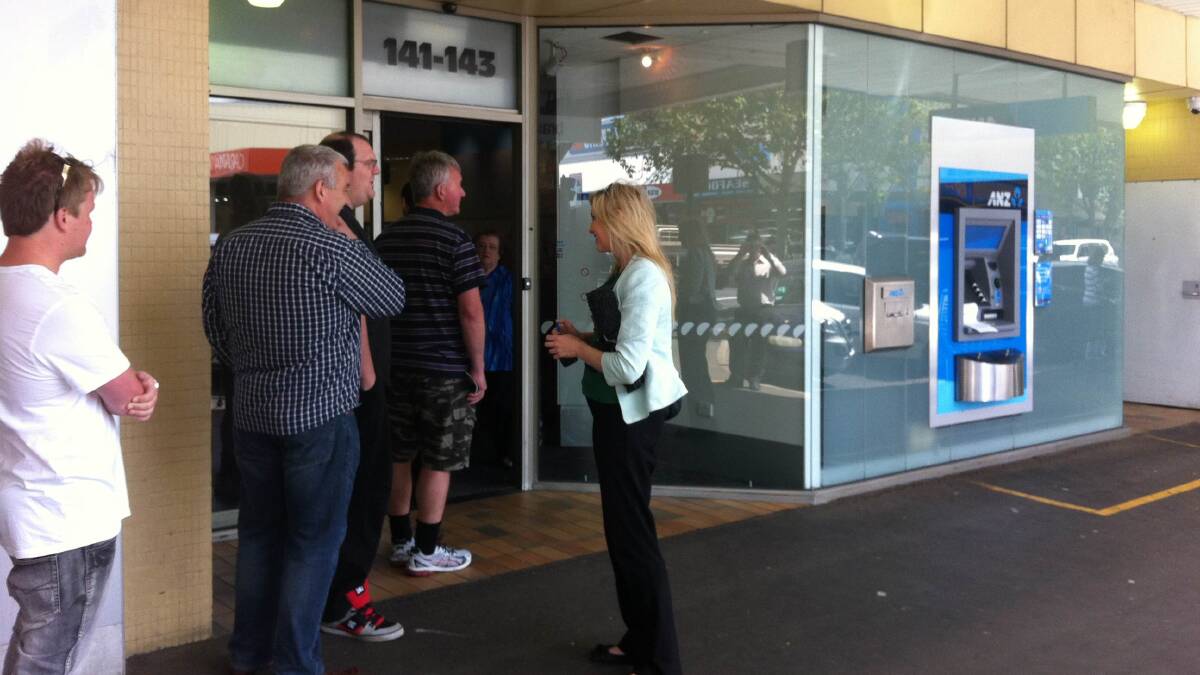 Customers are interviewed as they queue outside the Warrnambool ANZ branch. Photo: JONO PECH