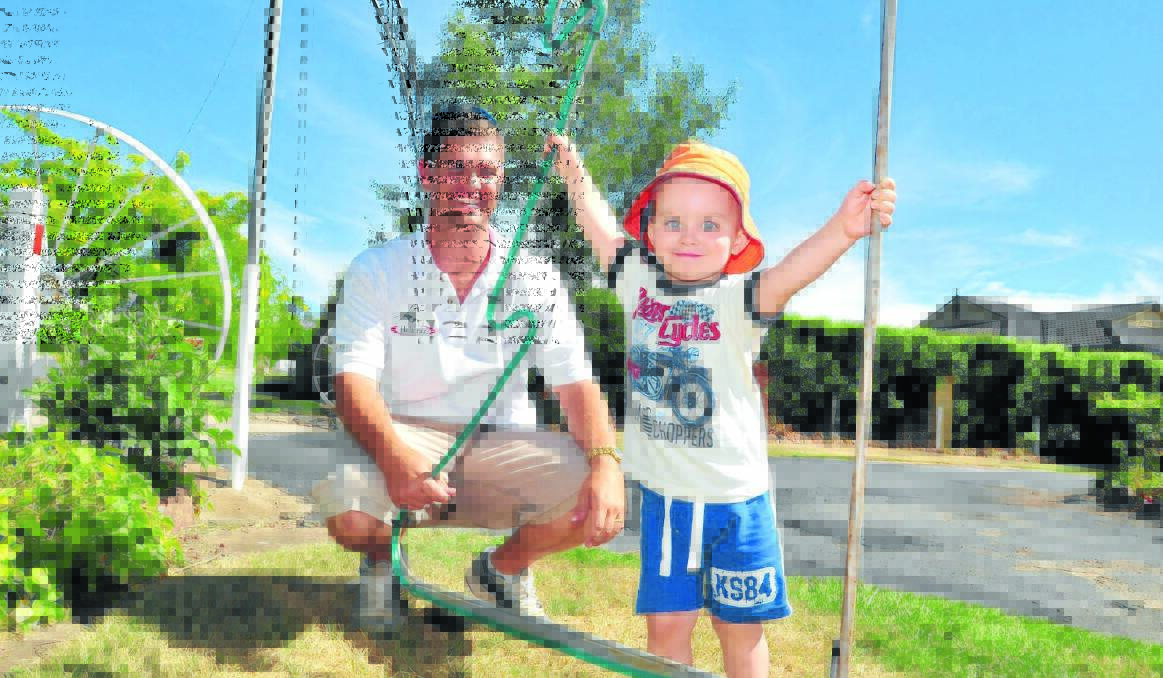 CHRISTMAS LIGHTS: Craig Murphy and his son Hunter, 2, put Christmas lights up around their home in preparation for the Central Western Daily's Christmas lights competition. Entries close tomorrow at noon. Photo: JUDE KEOGH         1203lights1