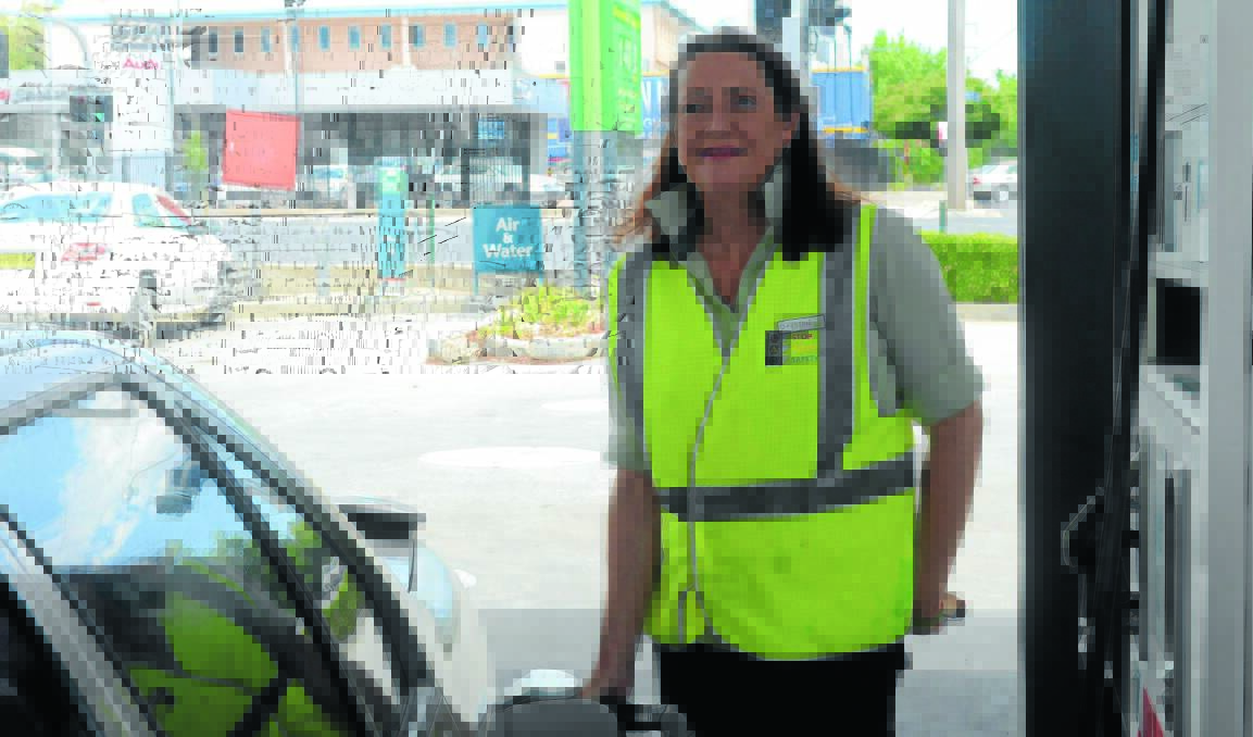 FILL HER UP: Woolworths Petrol employee Christine Davies practices her filling skills in preparation for tomorrow’s driveway service.      0123nkpetrol1