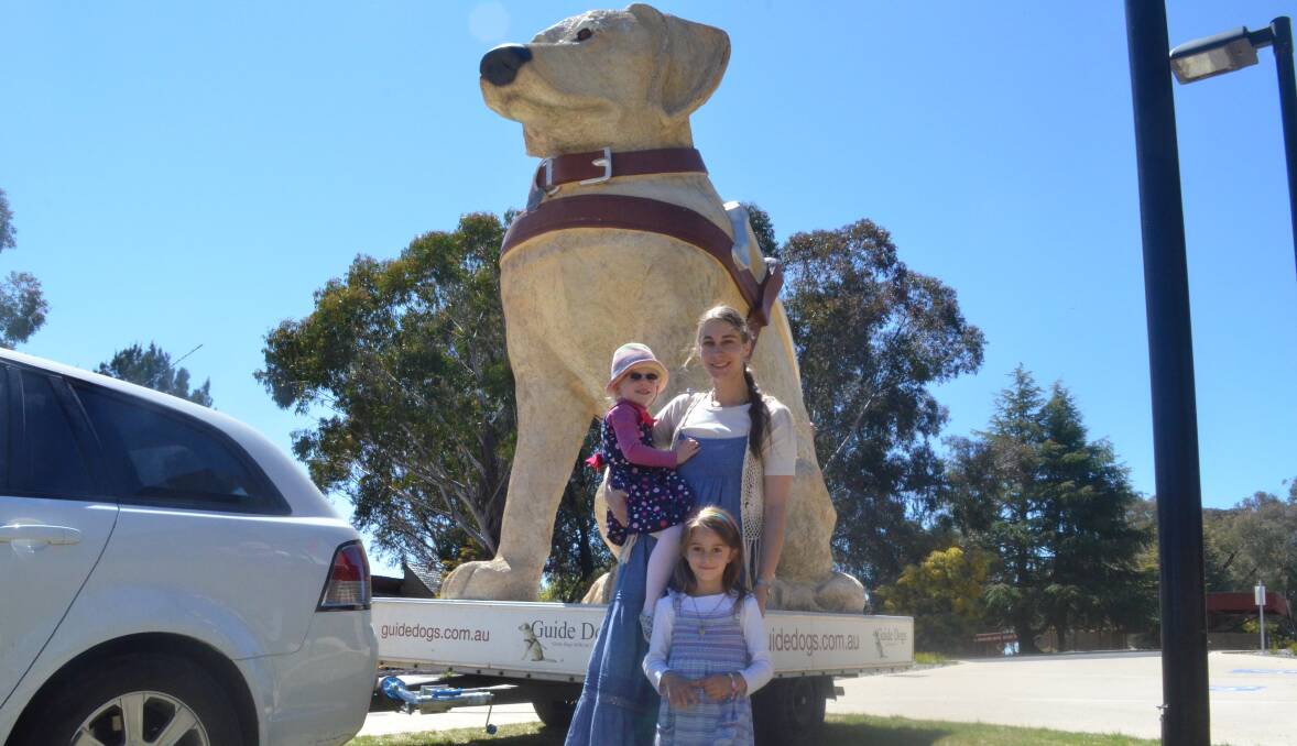 LOOKING AHEAD: Brigit Loecker, with daughter Julia, 3, who suffers from vision impairment and Sonja, 5, pictured in front of Gulliver the giant guide dog, is calling for Guide Dogs NSW/ACT to be included in the federal government's National Disability Insurance Scheme. Photo: NADINE MORTON  0925nmcampaingn4