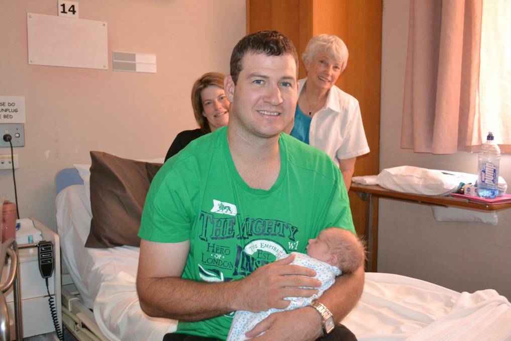 DUBBO: Ash Conn cuddles with new son Jackson, the first baby born in Dubbo in 2014, as wife Kellie and grandmother Wilma Ryan watch on.