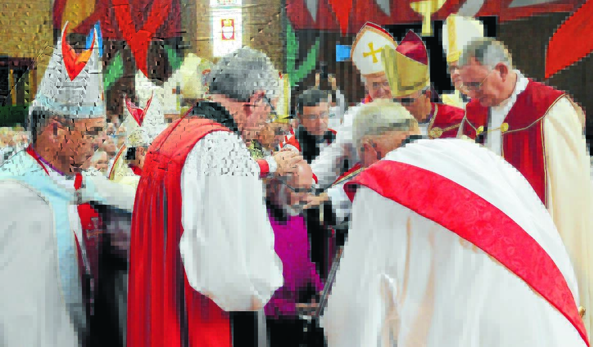 LAYING ON OF HANDS: Bishops lay their hands on the head of bishop-elect Ian Palmer during the consecration and installation ceremony on Saturday.  Photos: PHILL MURRAY 