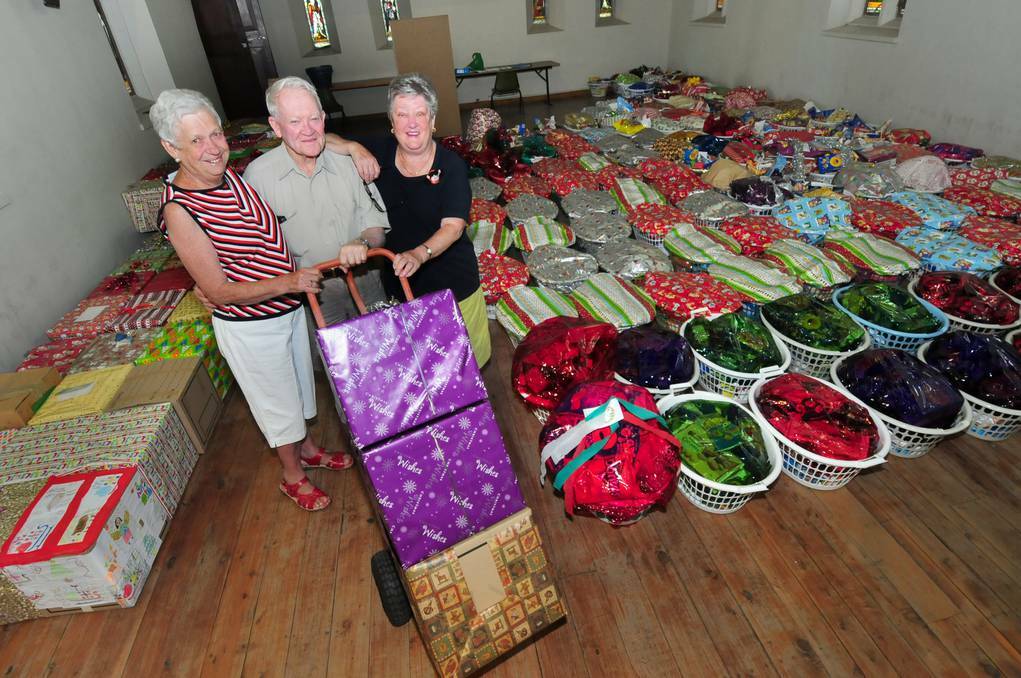 DUBBO:  DUBBO: Barb Kelly, Dan Sullivan and Carole O'Connor get hampers at St Brigid's Hall ready for distribution. Photo: LOUISE DONGES
