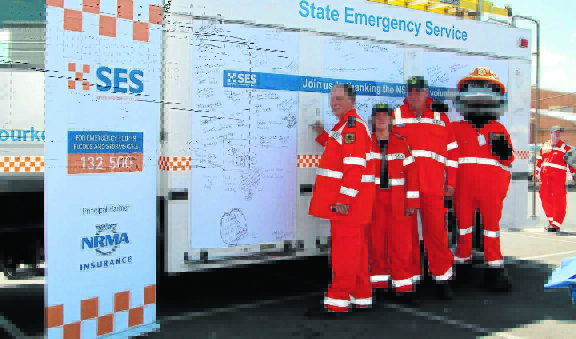 SIGNING FOR SUPPORT: State Emergency Service (SES) central west region chaplain Ron Murray, Bourke SES deputy controller Karen Keuning, Orange controller Steve Walsh and Paddy Platypus the SES’ roving ambassador. Photo: JEFF DEATH                     1112jdses01