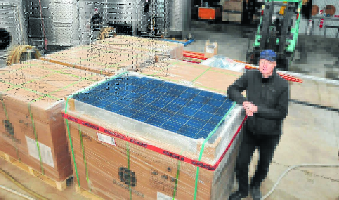 SUN CATCHER: Ross Hill Wines chief winemaker Phil Kerney with the solar panels ready to be installed today to bring the Wallace Lane winery one step closer to carbon neutrality. Photo: JUDE KEOGH                                                            0823solar1
