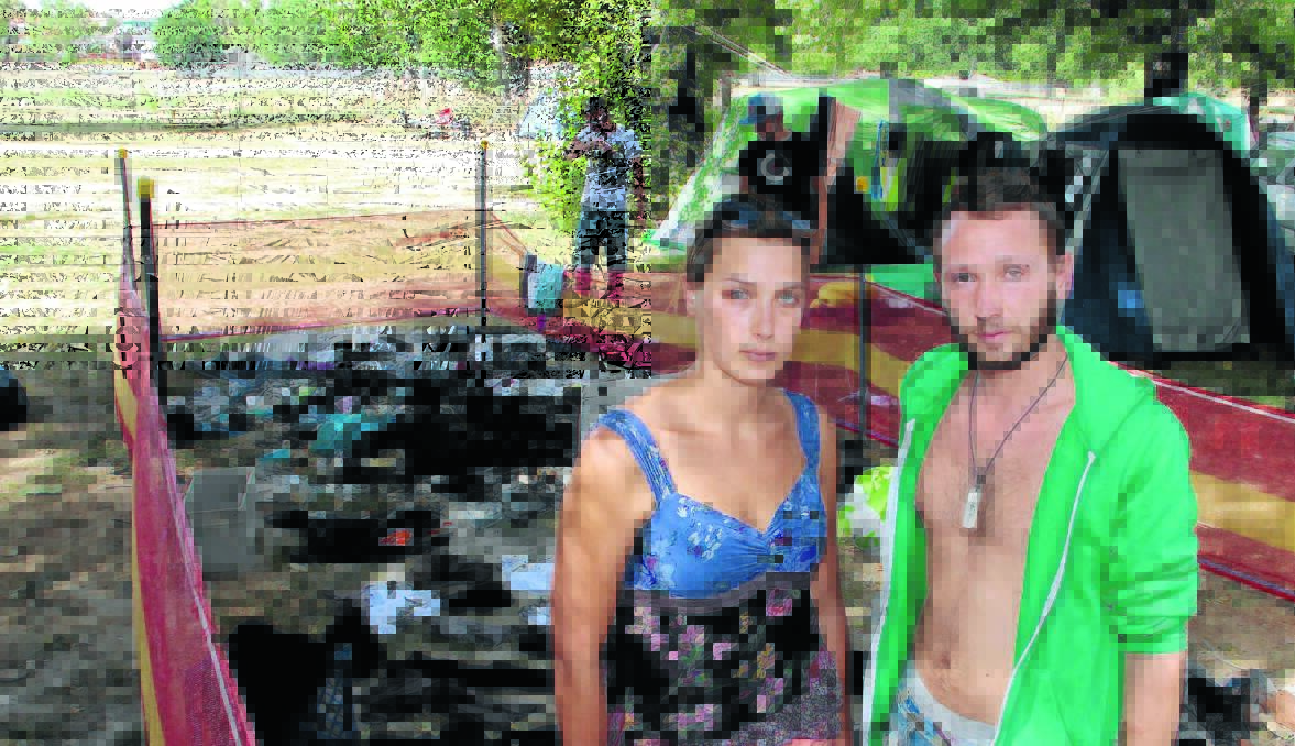 NOTHING LEFT: Backpackers Marie Dufour and Antoine Mickael attempt to salvage any clothes and possessions they can after their tent was destroyed by arsonists on New Year’s Eve.     									          Photo: JACK KEMP